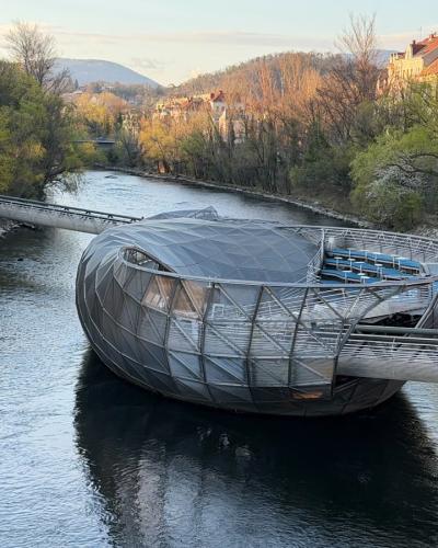Murinsel floating platform on the Mur River in Graz, seen from the riverbank