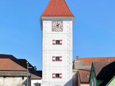 The white Ledererturm gate tower with its red roof on Wels town square