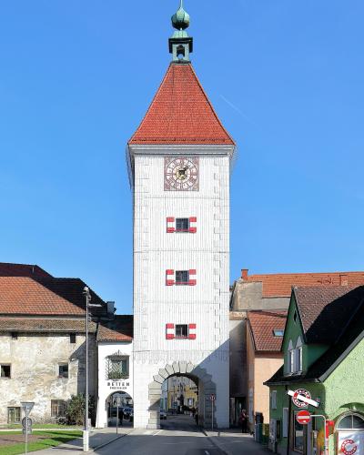 The white Ledererturm gate tower with its red roof on Wels town square