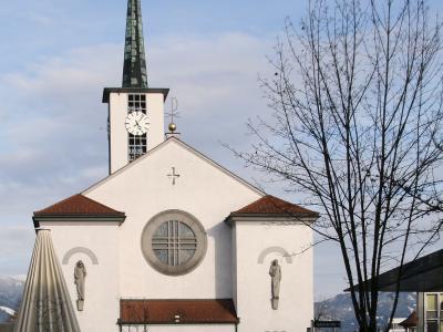 The white parish church of Sts Peter and Paul with its tall spire in the centre of Lustenau
