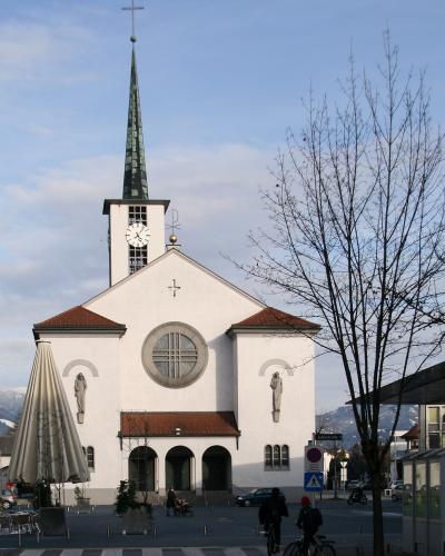 The white parish church of Sts Peter and Paul with its tall spire in the centre of Lustenau