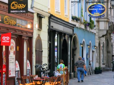 Colorful facades and cafe tables along Hofgasse in the Old Town (Altstadt) of Linz