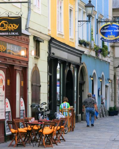 Colorful facades and cafe tables along Hofgasse in the Old Town (Altstadt) of Linz