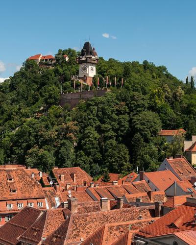 Schlossberg hill with the Uhrturm clock tower above the red rooftops of Graz, Austria