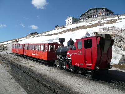 Red SchafbergBahn cog railway train at the Schafberg summit station above St. Wolfgang