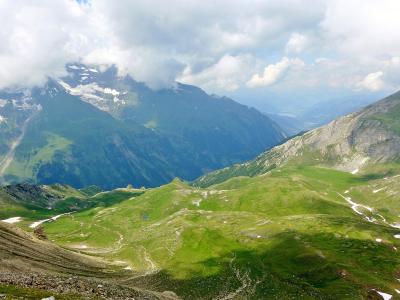 View from the Edelweißspitze over green alpine valleys to snow-capped peaks of the Hohe Tauern