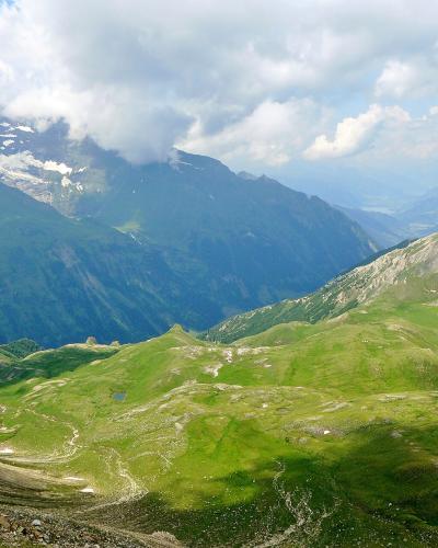 View from the Edelweißspitze over green alpine valleys to snow-capped peaks of the Hohe Tauern