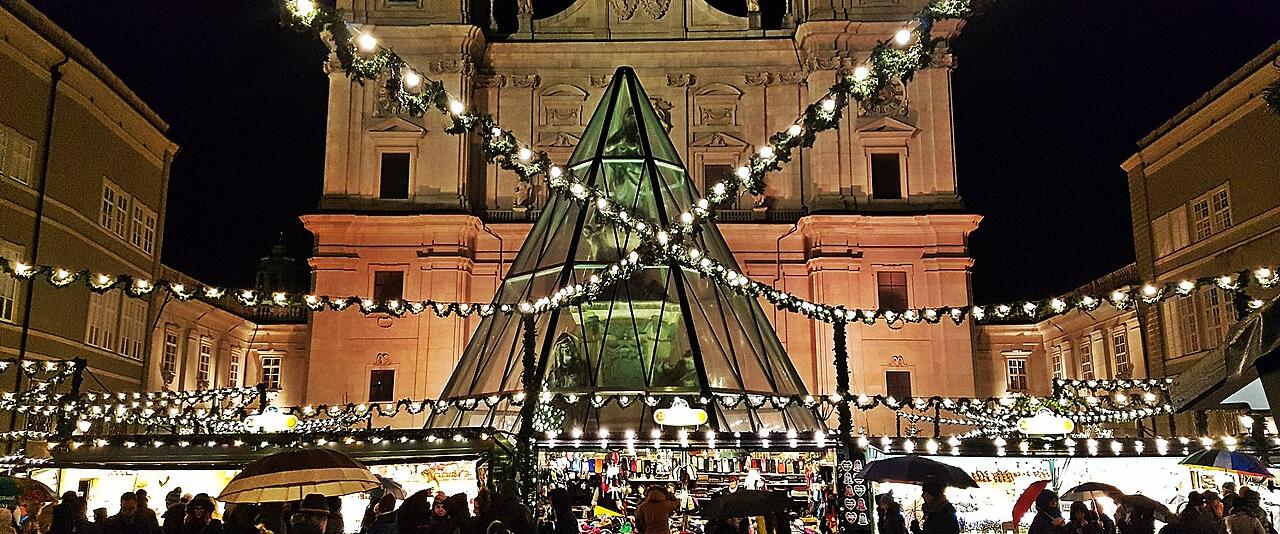 The Salzburg Christkindlmarkt on Domplatz at night, with garlands of lights in front of the cathedral