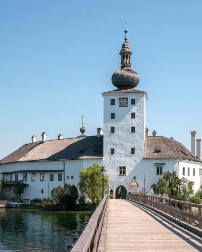 Seeschloss Ort castle on Lake Traunsee with its wooden footbridge in Gmunden