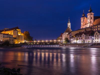 Schloss Lamberg and Steyr old town lit at dusk above the river confluence