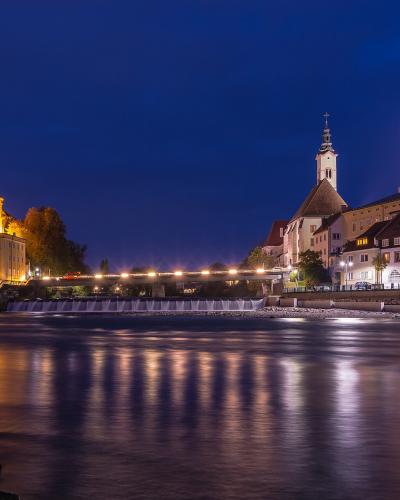 Schloss Lamberg and Steyr old town lit at dusk above the river confluence
