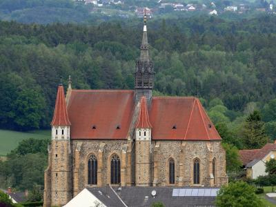 Gothic parish church of Mariasdorf against forested hills, Burgenland