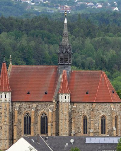 Gothic parish church of Mariasdorf against forested hills, Burgenland