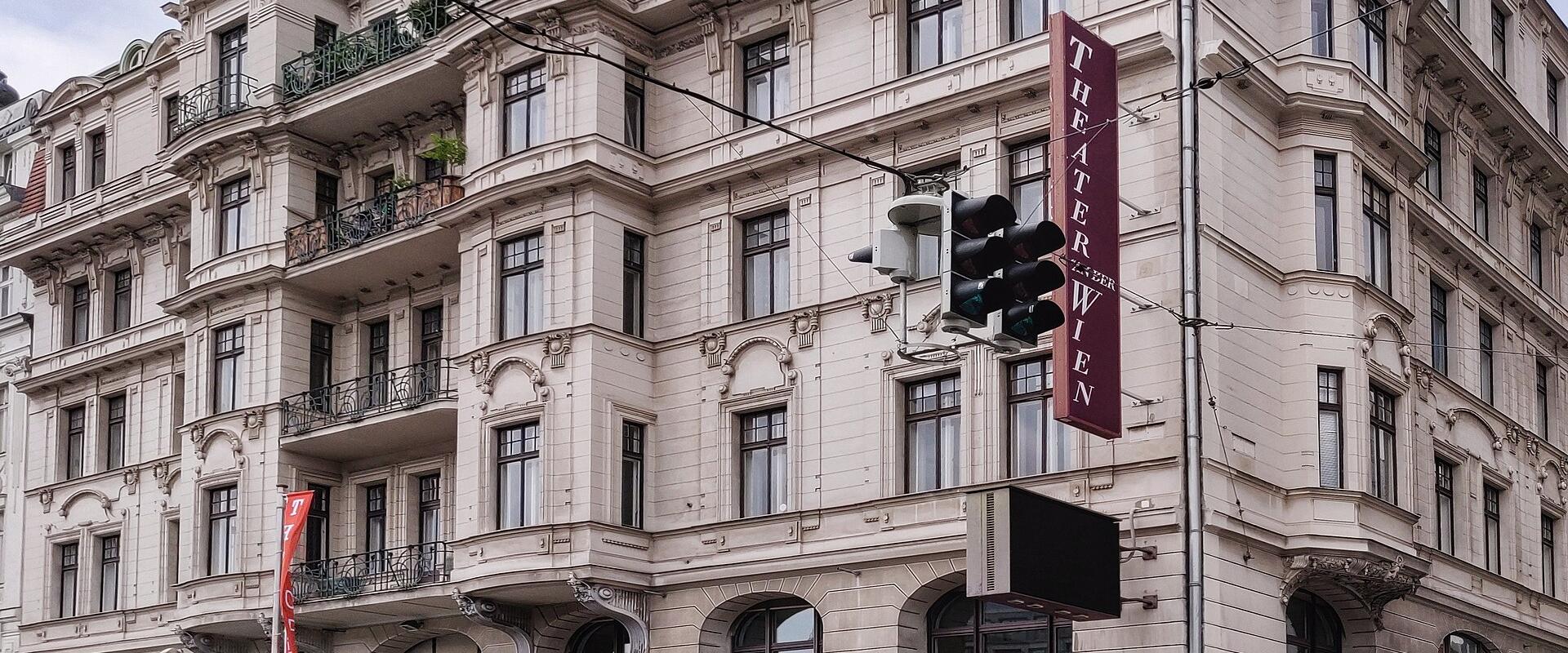The image shows the Theater an der Wien, a historic opera house and concert venue located at Linke Wienzeile 6 in Vienna, Austria, with visible signage reading "THEATER AN DER WIEN" and an Illy Caffè on the ground floor.