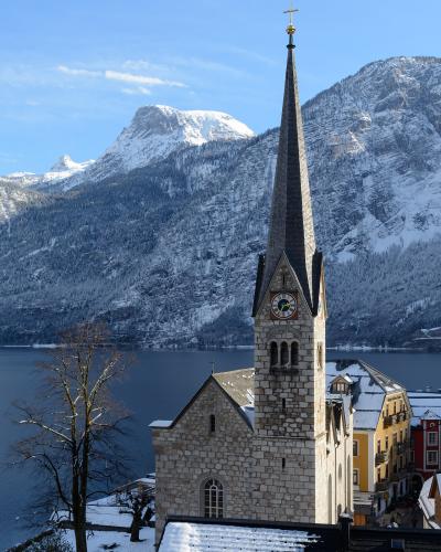 Lutheran church spire of Hallstatt on Lake Hallstatt beneath snow-covered Dachstein mountains