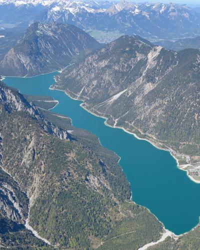 Aerial view of the turquoise Plansee lake framed by Tyrolean mountains near Reutte