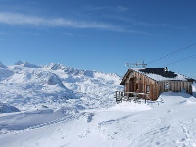 Alpine hut on Krippenstein with the snow-covered Dachstein massif behind