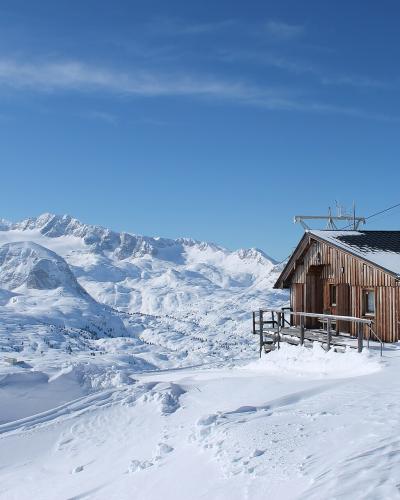 Alpine hut on Krippenstein with the snow-covered Dachstein massif behind
