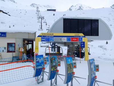 A ski lift station in a snowy mountain setting, featuring signage for the "Schlossalm" and "Weitmoser" lifts within the "Gastein" ski area.