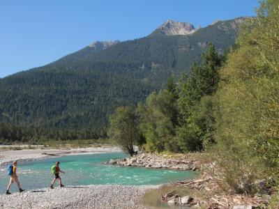 Hikers crossing the Lech's gravel bed on the Lechweg