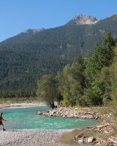 Hikers crossing the Lech's gravel bed on the Lechweg