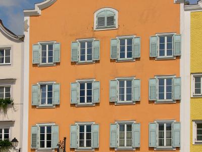 A tall, orange-colored historic building with a stepped gable facade, light blue shutters, and an "Oberbank" branch on the ground floor, located at street number 12.