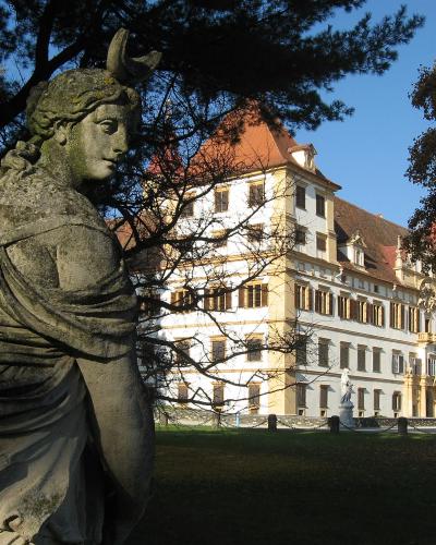 Baroque facade of Eggenberg Palace in Graz seen from the park with Diana statue