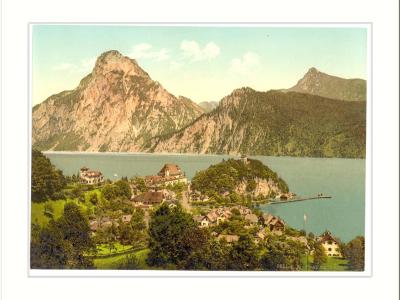 A vintage colorized postcard showing the village of Traunkirchen on the shore of Lake Traunsee with the Traunstein mountain rising prominently in the background.